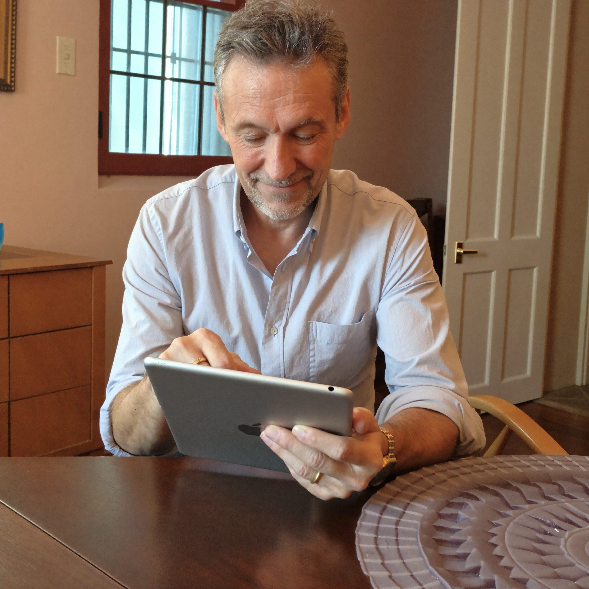 Thierry Baumann aide une élève à prendre en main sa tablette